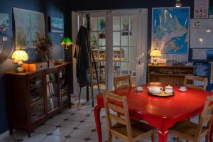 北圣罗斯Auberge jeunesse Rose des Vents的一间用餐室,配有红色的桌子和椅子