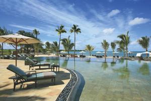 Beau Champ安娜希塔高尔夫及Spa度假酒店的一个带椅子和遮阳伞的游泳池以及大海