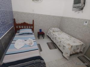 若昂佩索阿Pousada Refúgio的一间卧室配有两张床和椅子