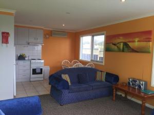 马拉库塔马拉库塔湖畔公寓的一间带蓝色沙发的客厅和一间厨房