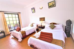 暹粒桑那龙精品度假村的一间卧室配有两张床和椅子