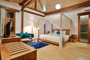 外南梦Villa SoLong Banyuwangi的一间带天蓬床的卧室和一间客厅