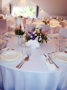 文盖尔斯卡－古尔卡Hotel Zacisze的一张桌子上放着白板和玻璃杯,上面放着鲜花