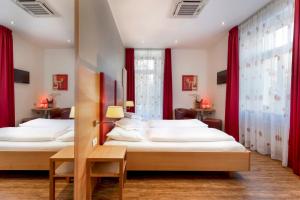 梅拉诺科尔平酒店的配有红色窗帘的客房内的两张床