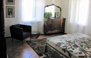 佩鲁贾Residenza storica con vista panoramica的一间卧室配有一张床、一把椅子和镜子