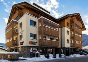 瑟弗浩斯Hotel Garni Alpenjuwel Residenz的前面有雪的大建筑