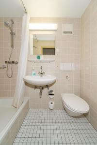 Niederau海德勒酒店的白色的浴室设有水槽和卫生间。