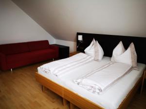 Neuberg an der MürzAltenbergerhof的一间卧室配有一张床和一张红色的沙发
