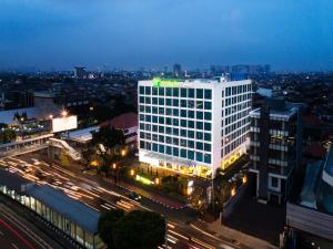 雅加达Holiday Inn Express Jakarta Matraman, an IHG Hotel的城市的一座有灯光的建筑