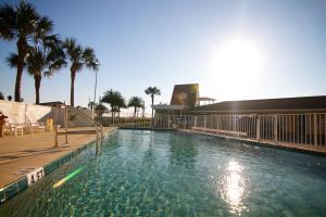 圣奥古斯丁Edgewater Inn - St. Augustine的一座棕榈树大型游泳池和一座建筑