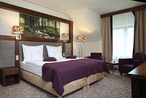 克雷尼察美居克雷尼察度假酒店 的一间卧室配有一张大床和紫色毯子