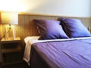 马赛Mélanie Marseille的一张带紫色枕头的床