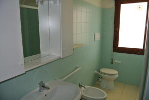利尼亚诺萨比亚多罗Condominio LISA的一间带水槽、卫生间和镜子的浴室
