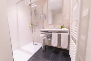 莫斯特约勒斯缪斯和罗齐尔酒店的白色的浴室设有水槽和淋浴。