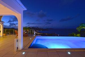 古斯塔维亚Mystique luxury villa at the heart of the island的夜间带游泳池的别墅