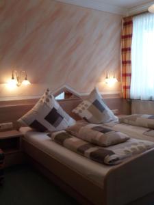 Rattenberg迪尔格酒店的一间卧室配有两张带白色枕头的床