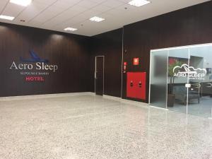 坎皮纳斯Hotel Aero Sleep Campinas的墙上有标牌的空房间和门