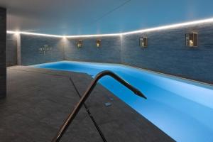 拉克吕萨St-Alban Hotel & Spa的蓝色灯光的房间的游泳池