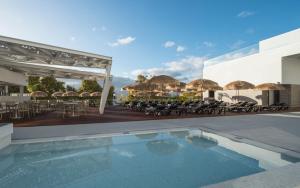 丰沙尔阿尔托丽都酒店的一个带游泳池、桌子和遮阳伞的度假村