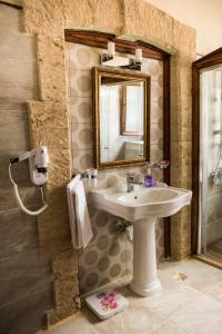 凯里尼亚kyrenia palace boutique hotel的一间带水槽和镜子的浴室