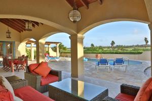 棕榈滩Aruba Dreams的一个带桌椅的户外庭院和一个游泳池