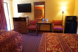 瓦恩兰RELAX INN的酒店客房带两张床和一张桌子以及椅子。