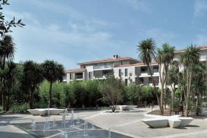 圣特罗佩Luxury & Exclusive Resort的庭院前方的棕榈树建筑