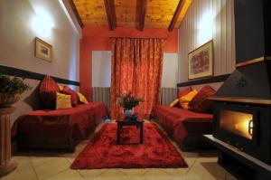 卡拉维塔Aphrodite's Inn Kalavrita的客厅设有2张红色的沙发和壁炉