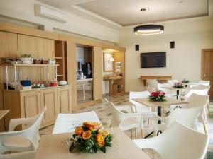 福尔米亚海湾酒店的一间设有桌子和白色椅子的等候室