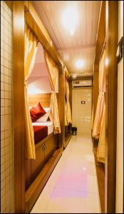 孟买Qubestay Airport Capsule Hotel & Hostel的一间小房间,配有一张床和一个走廊