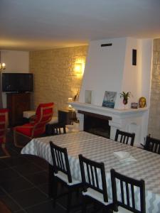 Bernières-sur-MerGîte de Eric et Rose的客房设有桌椅和壁炉。