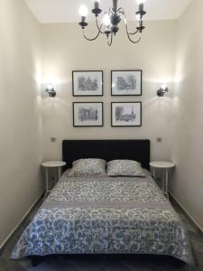 尼斯Beautiful apartment Rue De La Croix Vieux Nice的卧室配有一张床,墙上有三幅照片