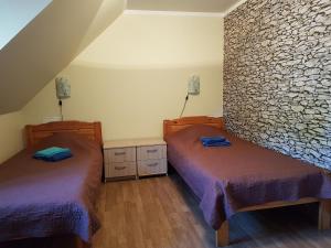 MärjamaaMärjamaa Hostel的一间卧室设有两张床和石墙