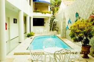 福塔莱萨博雅乐斯酒店的庭院内一个带椅子和桌子的游泳池