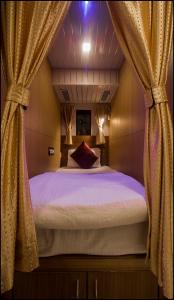 孟买Qubestay Airport Capsule Hotel & Hostel的一间卧室配有一张带窗帘的大床