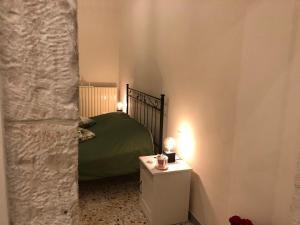 普蒂尼亚诺CASA CAIROLI PUTIGNANO的一间卧室配有绿色的床和一张带灯光的桌子