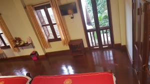 琅勃拉邦Villa Kee Lee Hotel 1的客厅设有2把红色椅子和窗户