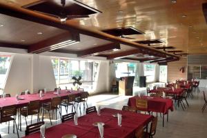 InāniInani Royal Resort的一间设有红色桌椅和窗户的用餐室