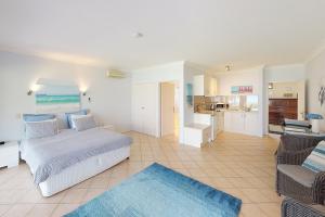 圣殿海岬Paradise Beach Apartments的一间卧室设有一张床和一间客厅。