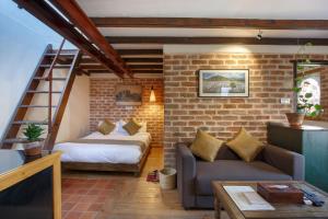 加德满都Thamel Villa Heritage Hotel的带沙发和床的客厅以及砖墙
