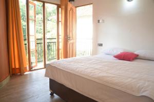 基图尔格勒White Villa Kitulgala的一间卧室设有一张大床和一个大窗户