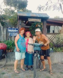 乌汶Rim Than View Resort的一群站在自行车旁的三名妇女