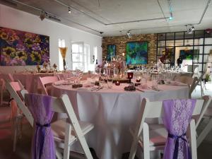BasthorstKunst Pension Frahm的一张桌子,上面有粉红色的桌布和椅子