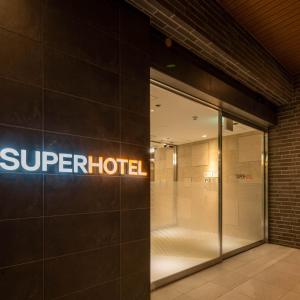 饭田市Super Hotel Nagano Iida Inter的大楼一侧超级酒店的一个标志