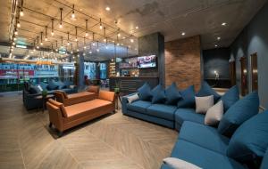 吉隆坡Travelodge Chinatown Kuala Lumpur的一间设有蓝色沙发和电视的等候室