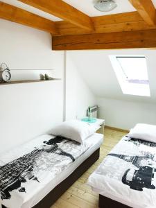 拉伊恰Apartamenty Centrum Rajcza的配有白色墙壁和木制天花板的客房内的两张床