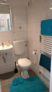 汉诺威Comfort的浴室设有卫生间、水槽和蓝色垫子。