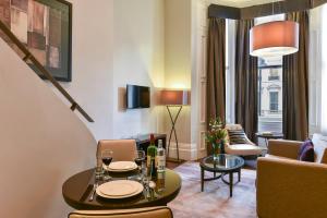 伦敦伦敦女王门辉盛阁国际公寓的客厅配有桌子和沙发