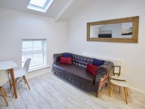 滨海索尔特本Host & Stay - The Surfer's Loft Apartment的客厅配有棕色的沙发和镜子