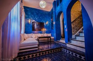 舍夫沙万丽娜莱德spa酒店的客厅设有白色沙发和蓝色的墙壁。